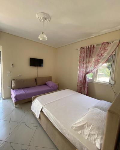 a bedroom with two beds and a couch at Gerard apartments in Sarandë