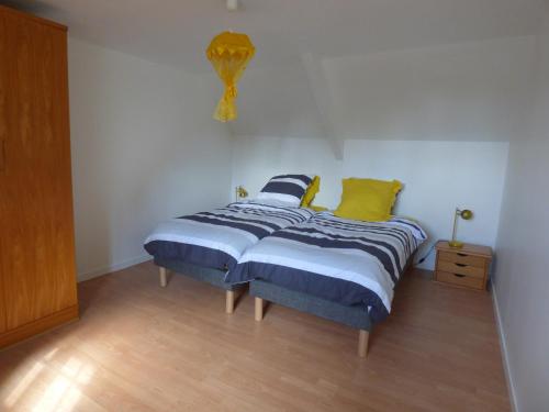 a bedroom with a bed with blue and yellow pillows at gite de kerveg in Bégard