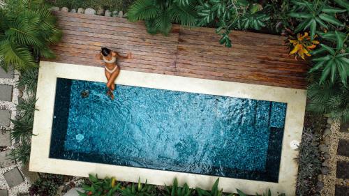 uma mulher à beira de uma piscina em El Hábita CASA SELVA em Santa Teresa