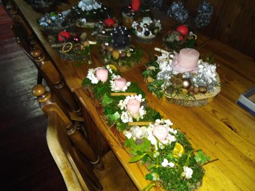 a wooden table with flowers and plants on it at Smučarska koča in Kotlje