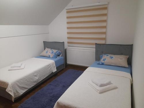 Duas camas num pequeno quarto com duas almofadas em Pejovic em Višegrad