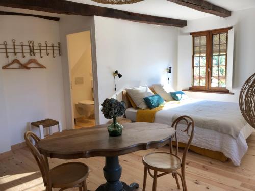 a bedroom with a bed and a table and chairs at LA CONQUISE in Conques-en-Rouergue