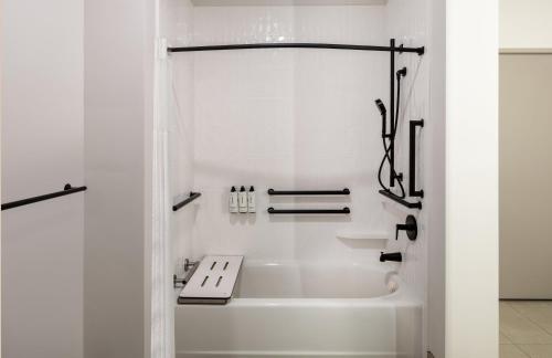 a white bathroom with a tub and a sink at Atwell Suites - DENVER AIRPORT TOWER ROAD by IHG in Denver