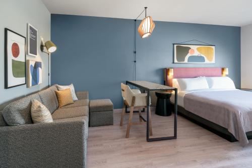 a hotel room with a bed and a couch at Atwell Suites - DENVER AIRPORT TOWER ROAD by IHG in Denver