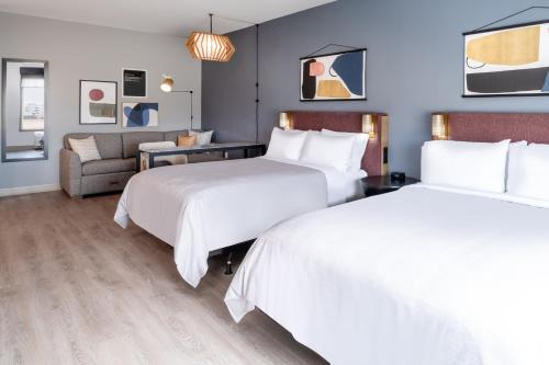 a hotel room with two beds and a couch at Atwell Suites - DENVER AIRPORT TOWER ROAD by IHG in Denver