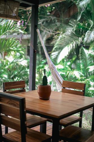 a wooden table with two chairs and a hammock at El Hábita CASA MAR in Santa Teresa Beach