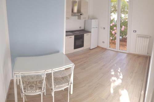 uma cozinha com uma mesa branca e cadeiras num quarto em Borgo and Bike em Finale Ligure