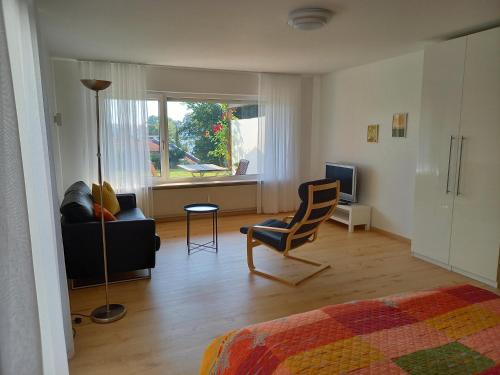 メーアスブルクにあるFerienwohnung Riposoのリビングルーム(ベッド1台、ソファ、椅子付)