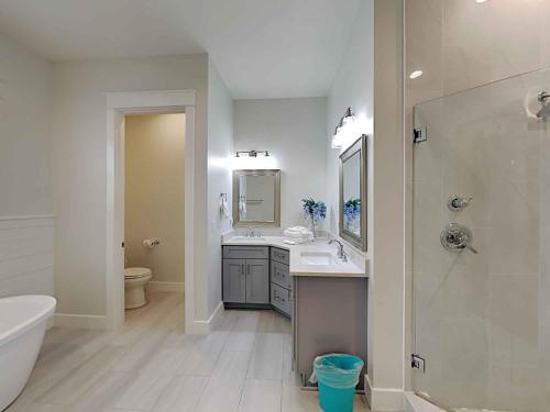 Un baño con dos lavabos y una ducha y un inodoro. en Seabreeze 30A, en Blue Mountain Beach