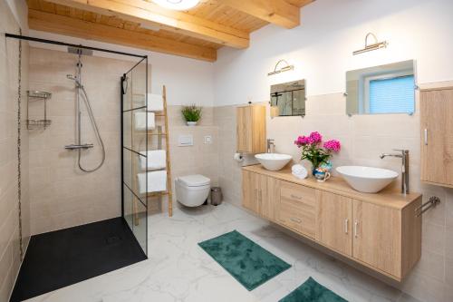 a bathroom with two sinks and a shower at Chalets Lunz am See in Lunz am See
