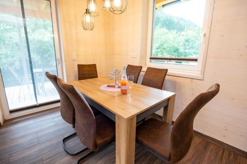 a dining room with a wooden table and chairs at Chalets Lunz am See in Lunz am See