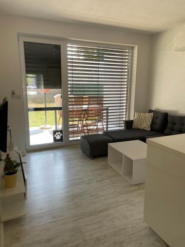 a living room with a couch and a table at Sunny apartment on the lakes in Senec