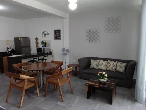a living room with a couch and a table and chairs at Centrico Depto (101) in Cancún