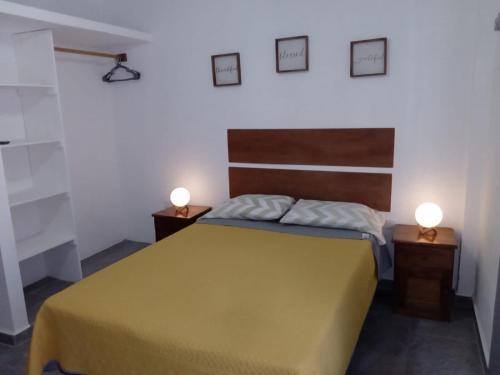 a bedroom with a bed and two lights on the wall at Centrico Depto (101) in Cancún