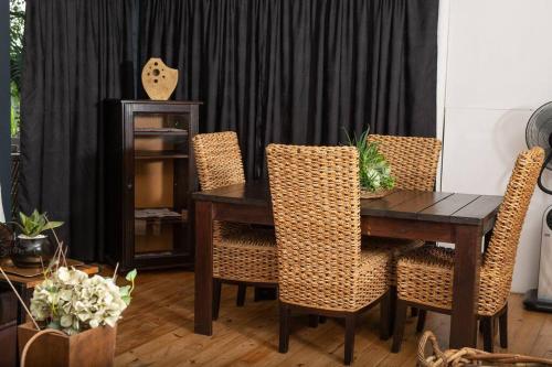 a dining room with a wooden table and chairs at HomeSweetHome Farm Cottage in Nelspruit