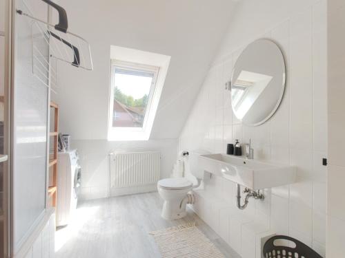 a white bathroom with a sink and a mirror at INIKAMA - Bohemian Apartment im Grünen in Rosengarten