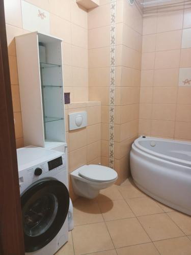 a bathroom with a washing machine and a toilet at Mieszkanie Kopernika in Iława