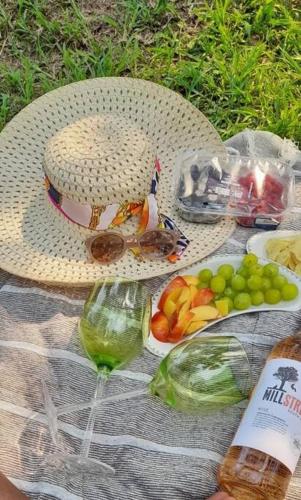 a picnic with a basket of fruit and a wine glass at HomeSweetHome Farm Cottage in Nelspruit