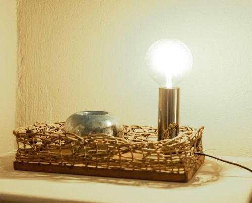 a light in a wicker basket with a lamp at HomeSweetHome Farm Cottage in Nelspruit