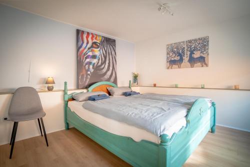 a bedroom with a blue bed and a chair at Akram Appartement I - Zentral und Ruhig in Hildesheim