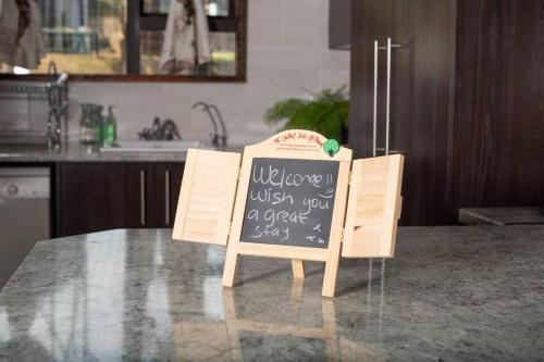 a chalkboard sign sitting on a table in a kitchen at HomeSweetHome Farm Cottage in Nelspruit