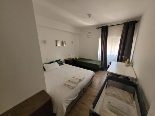 a small bedroom with a white bed and a window at Treetops Lisbon Apartment in Lisbon