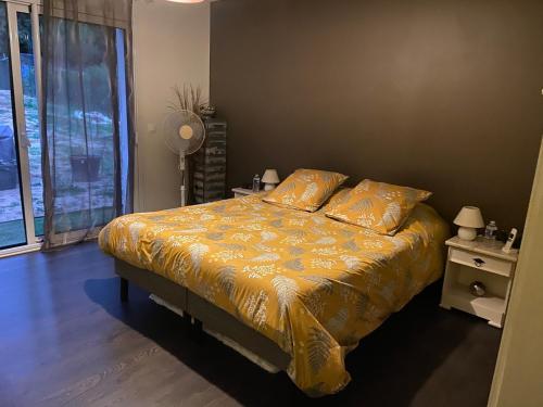 1 dormitorio con 1 cama con sábanas amarillas y ventana en La halte chambre chez l habitant, en Bonnes