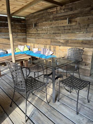une table en verre et deux chaises dans une cabine dans l'établissement L'escale au Port Miniature de Saint Savinien, à Le Mung