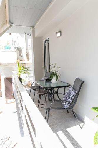 a balcony with a glass table and chairs at Apartments Barbie in Rethymno Town