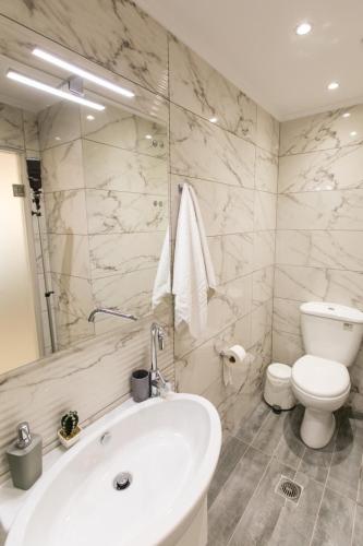 a bathroom with a white sink and a toilet at Apartments Barbie in Rethymno Town