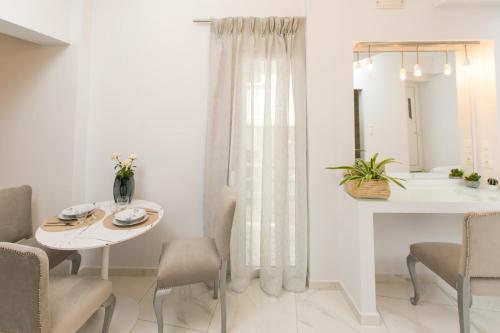 a white dining room with a white table and chairs at Apartments Barbie in Rethymno Town
