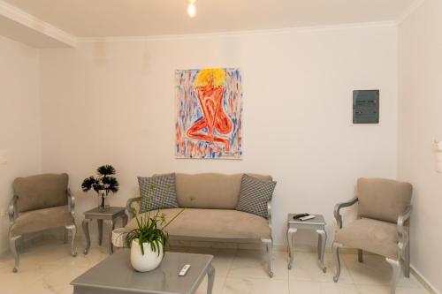 a living room with a couch and two chairs at Apartments Barbie in Rethymno Town