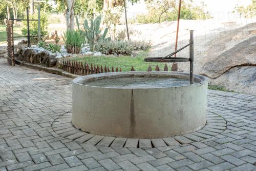 a fountain in the middle of a brickickedicked yard at HomeSweetHome Farm Cottage in Nelspruit