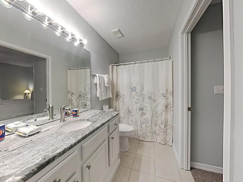 a bathroom with a sink and a toilet and a mirror at Grand Caribbean #306 West in Perdido Key