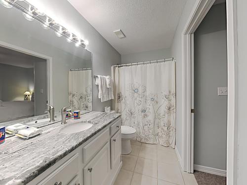 a bathroom with a sink and a toilet and a mirror at Grand Caribbean Perdido Key #306 West in Perdido Key