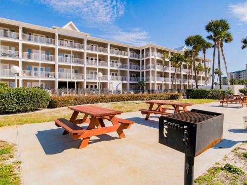 a group of picnic tables in front of a large building at Grand Caribbean Perdido Key #303 West in Perdido Key