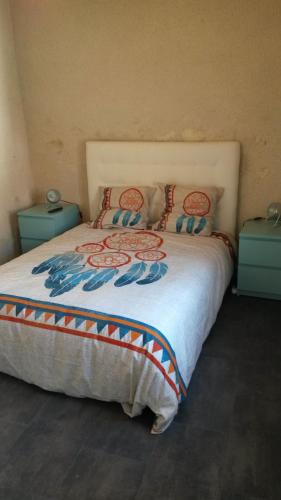 um quarto com uma cama grande e 2 almofadas em Gîte Dodo Lé La em Saint-Aignan