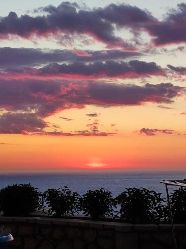 a sunset over the ocean with the sun setting at MELIKIRON LUXURY APARTMENTS in Agios Nikitas