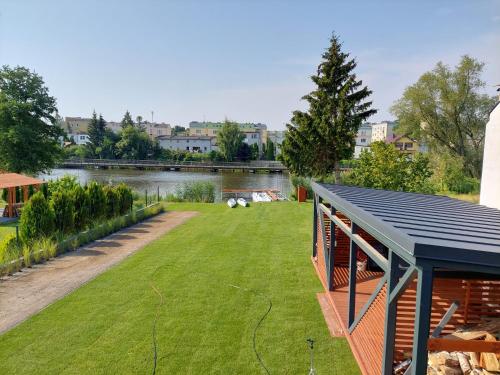 a house with a large yard next to a river at Turystyka 4jeziora Iława in Iława