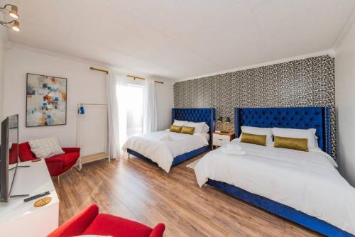 a bedroom with two beds and a red couch at Music Row Retreat with Pool and Free Parking, Walk to Bars! in Nashville