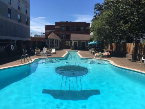 a large swimming pool with blue water at Music Row Retreat with Pool and Free Parking, Walk to Bars! in Nashville