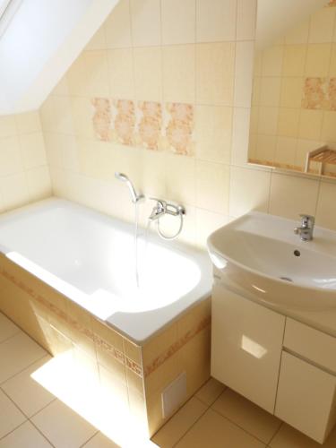 La salle de bains est pourvue d'une baignoire et d'un lavabo. dans l'établissement Apartmány Na Valše, à Sušice