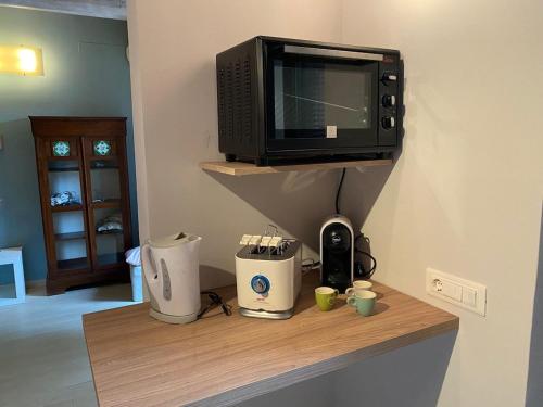 a microwave sitting on top of a wooden shelf with coffee makers at Bouganville House in Senigallia