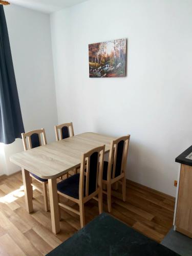 a dining room with a wooden table and chairs at Apartmány Na Valše in Sušice