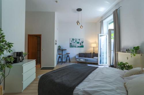 a bedroom with a large bed and a living room at Cozy-Livings Altbau mit Terrasse und Küche am Stadtpark in Bad Nauheim