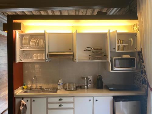a kitchen with white cabinets and a sink and a microwave at CASA SAUTO Family Suite next to the Cathedral in Mexico City