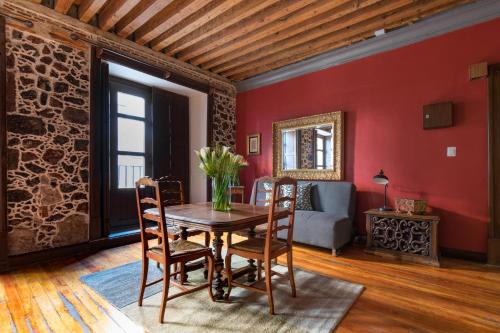a dining room with red walls and a table and chairs at Historic Suite w balconies to Cathedral & Rooftop CASA SAUTO 5 in Mexico City