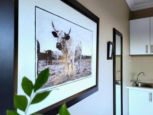 a picture of a cow on a wall in a kitchen at Suite 14- Deja' Blu Bed and Breakfast- East London in East London