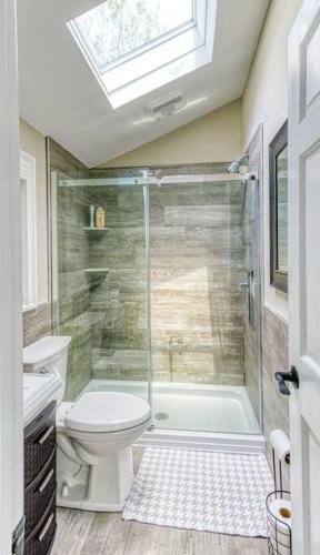 a bathroom with a shower with a toilet and a sink at Beach cottage villa in Baiting Hollow