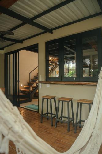 a view of a room with two stools and windows at El Hábita CASA SELVA in Santa Teresa Beach
